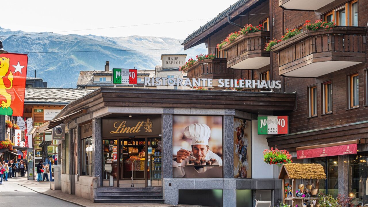 ZERMATT, SWITZERLAND - August 26, 2021: Traditional local houses and shops in the centre of Zermatt town in the Valais canton of Switzerland
