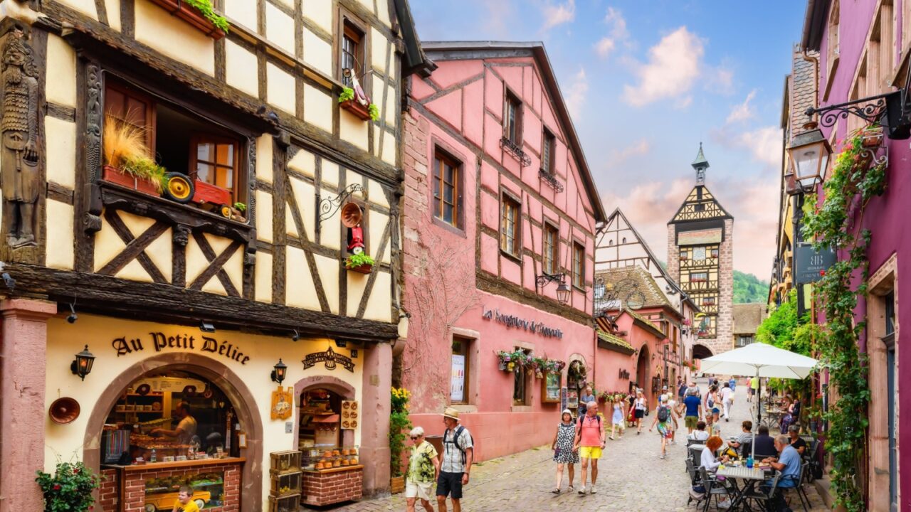 Riquewihr, FRANCE - June 19, 2023: Famous vine route and tourist " romantic road". Streets of the old town with a view of the Dolder Tower, the medieval bell tower and the clock. Beautiful villages