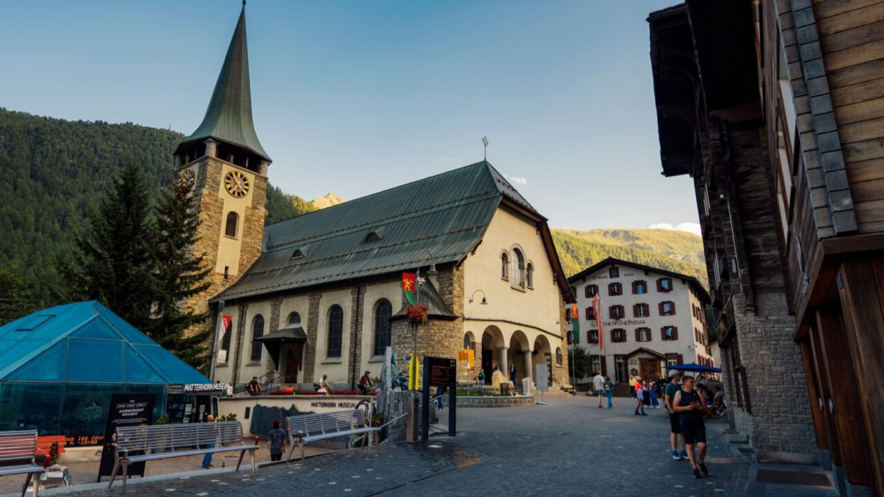 Zermatt Switzerland , 22 August 2024 : Zermatt Bahnhofstrasse Main shopping street full of people with old Swiss wooden houses and dramatic light during summer 2024 in Zermatt Switzerland
