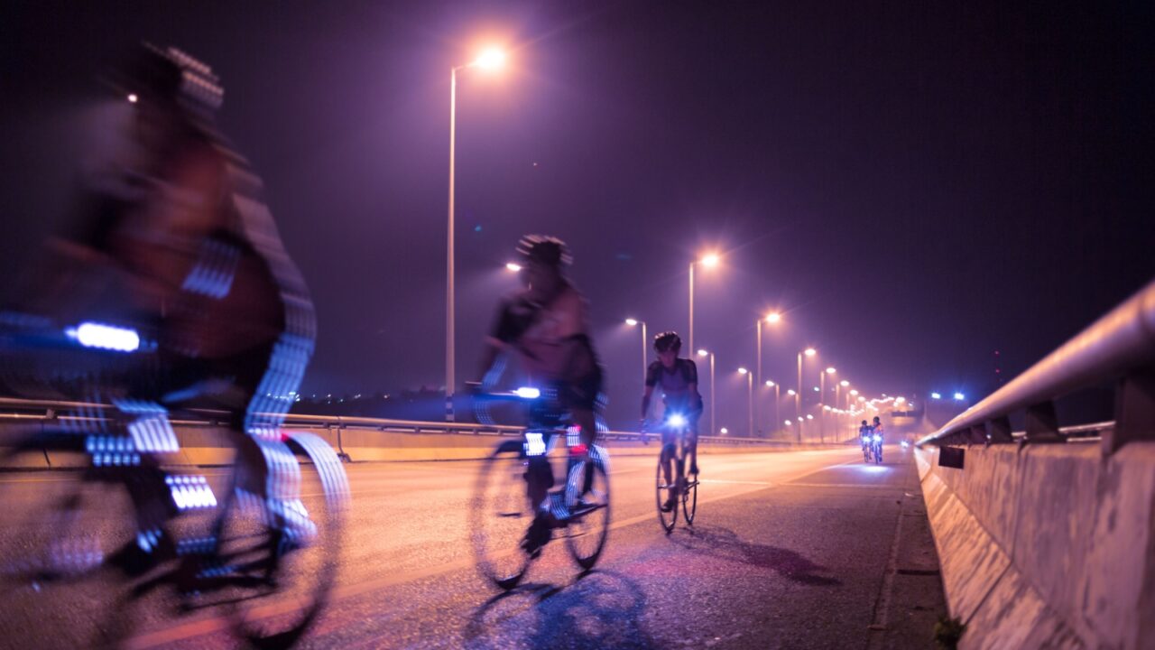 Blurry of Cyclists ride through lighted city