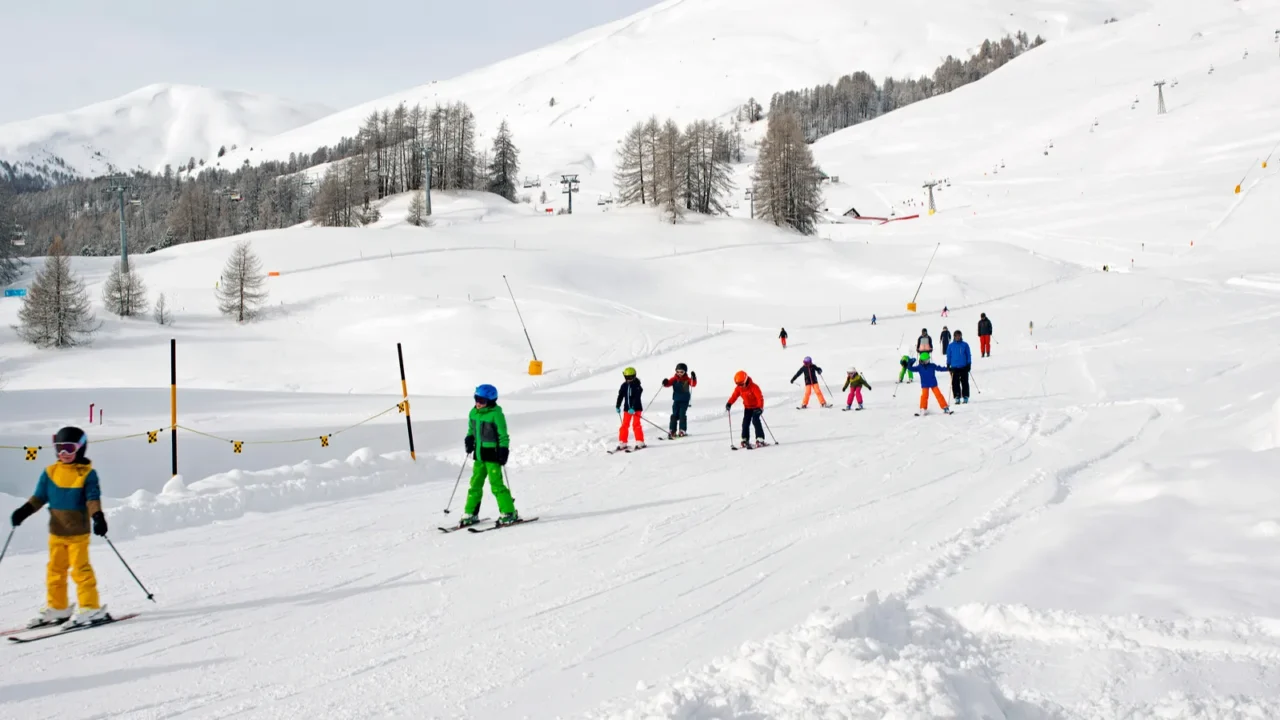 a ski teacher and kids learning skiing in the ski