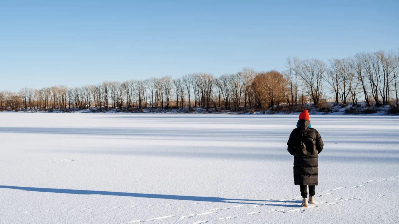 a young girl in a bright hat walks on a