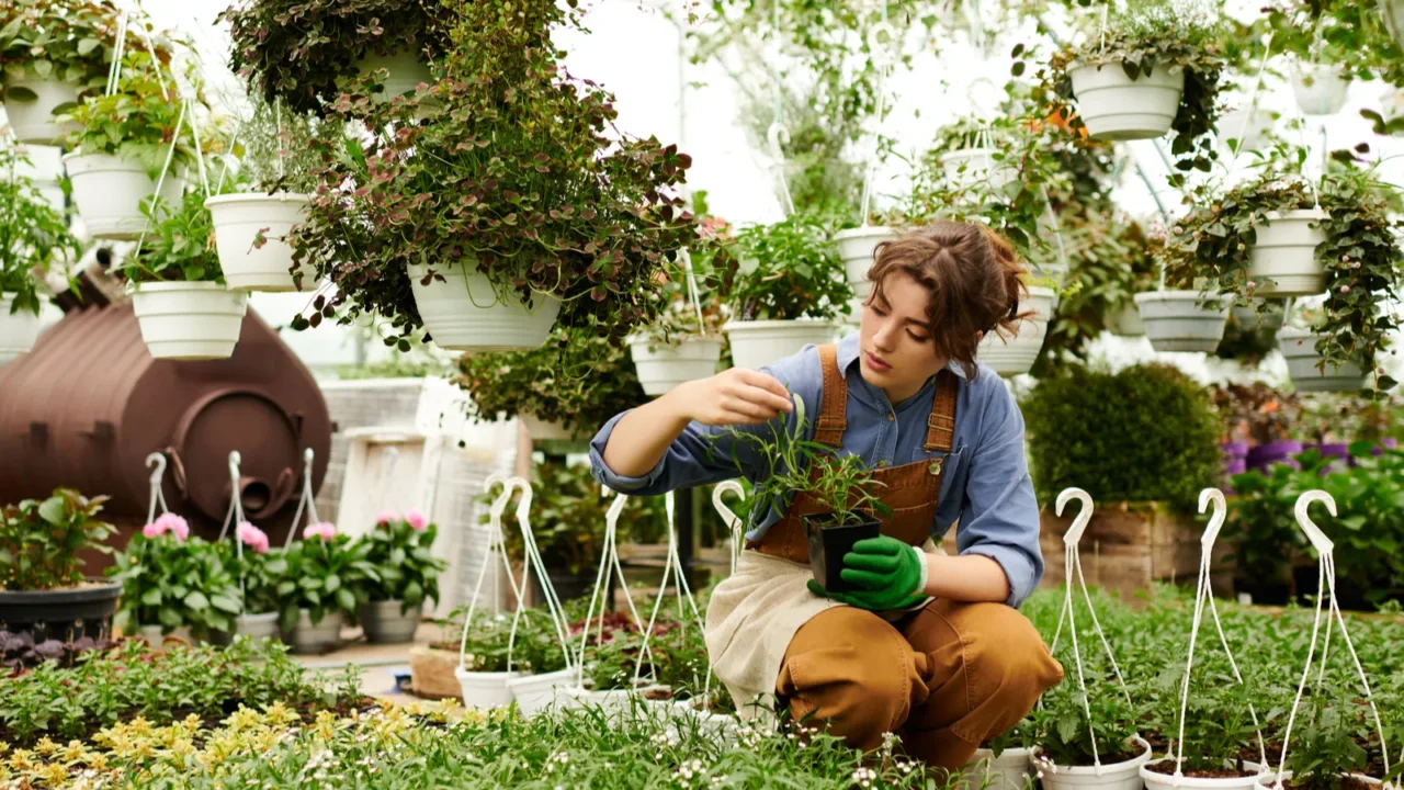 a young woman tends to her plants in a lush