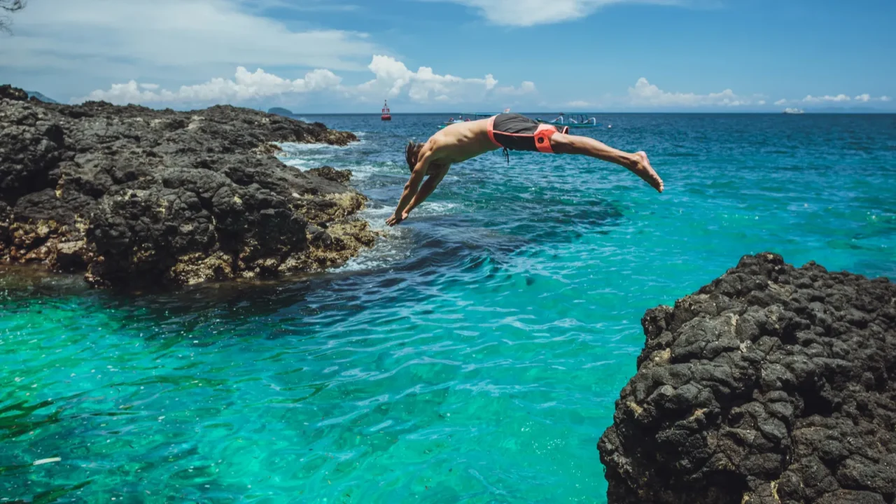 attractive man jumping into water