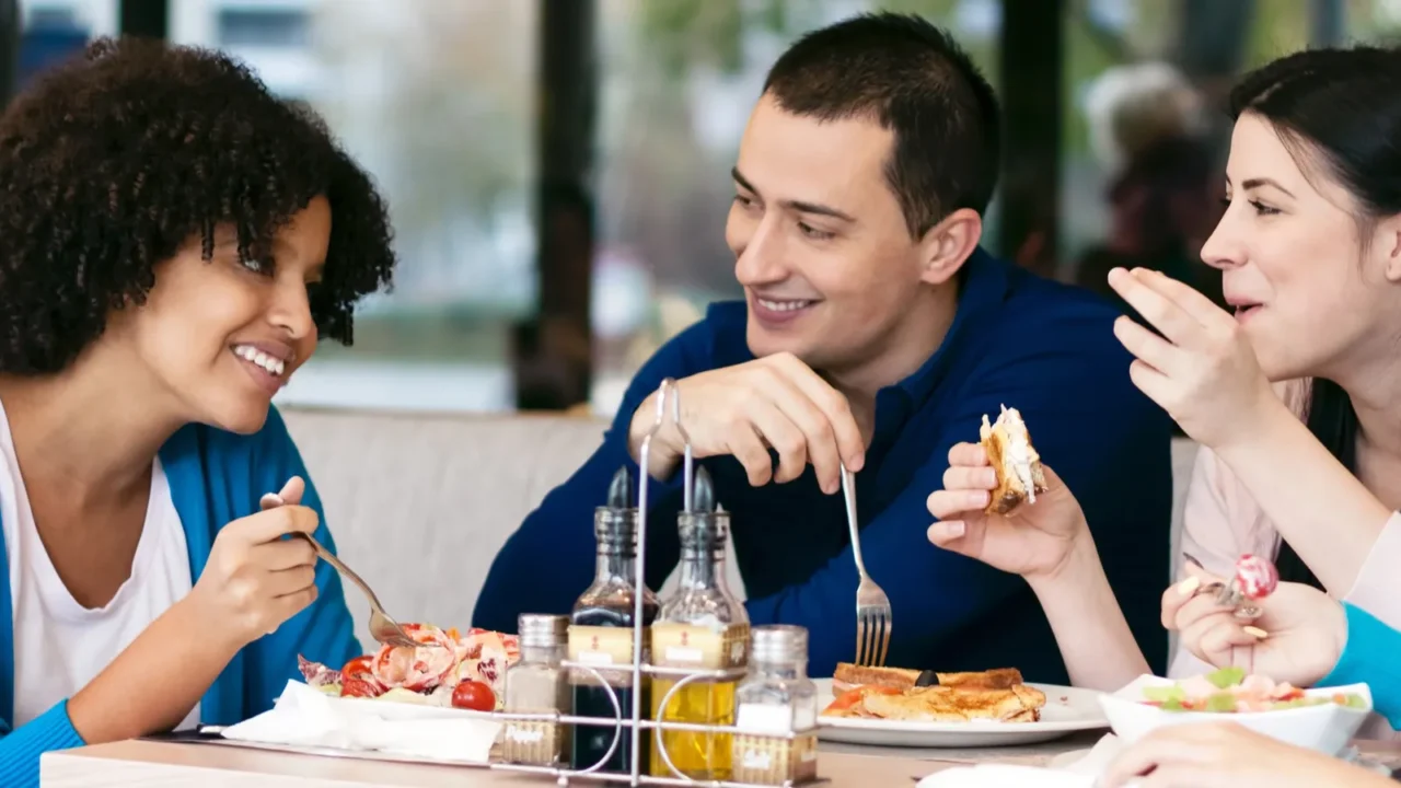 cheerful friends chatting while lunch