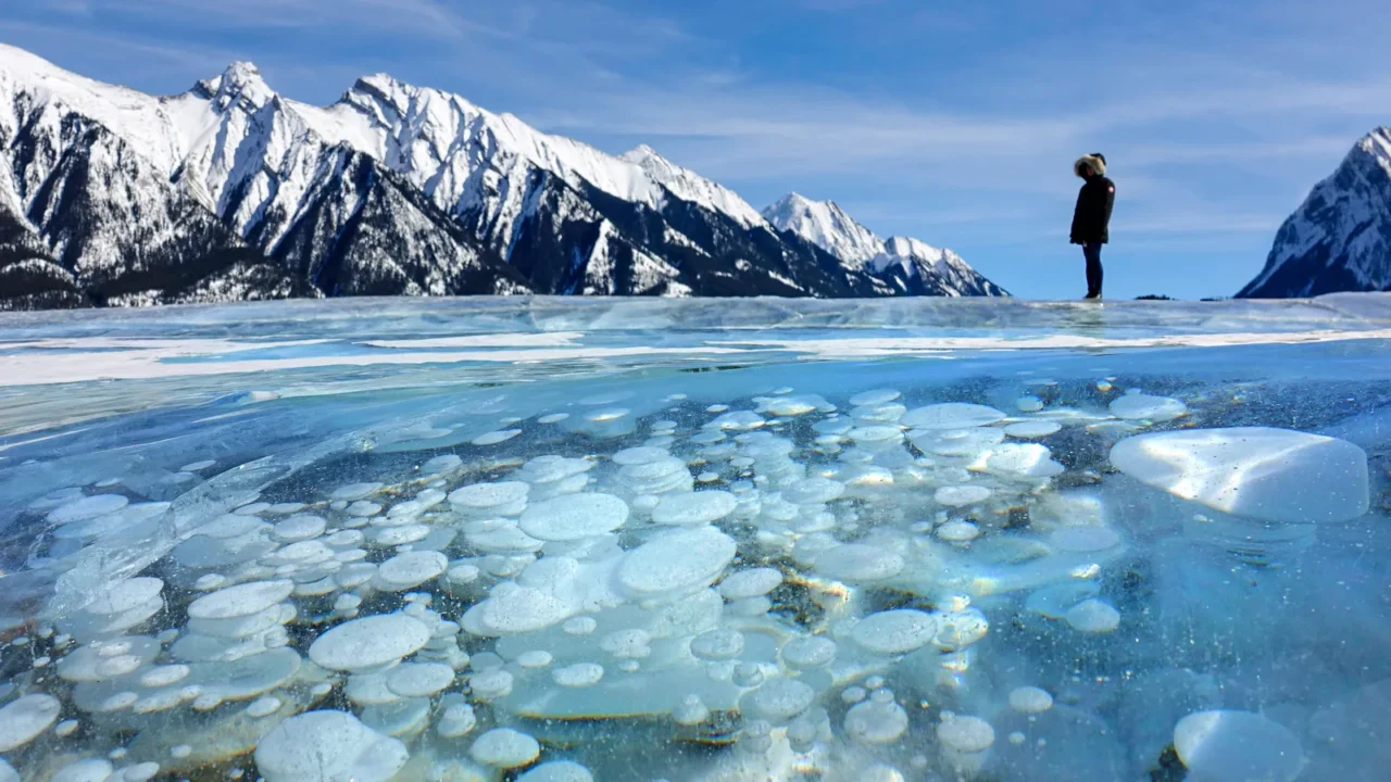 close up female tourist observes the frozen lake filled with