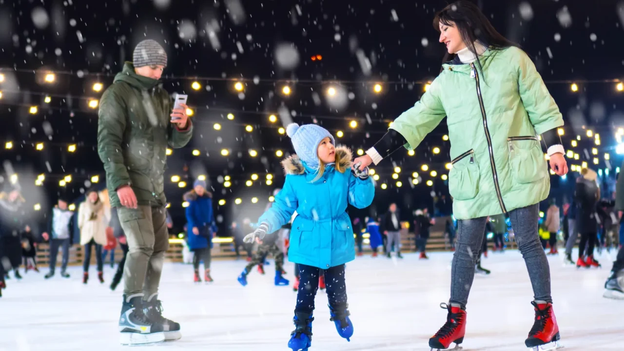 family on the ice skating rink dad shoots family video