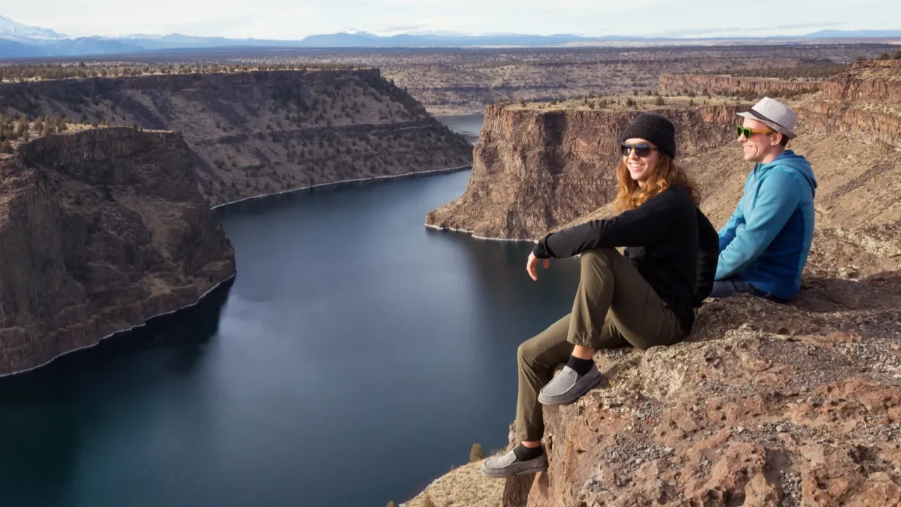 friends sitting at the edge of a cliff and enjoying