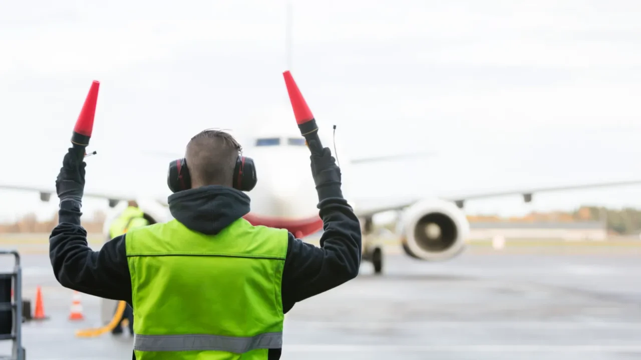 ground crew signaling to airplane