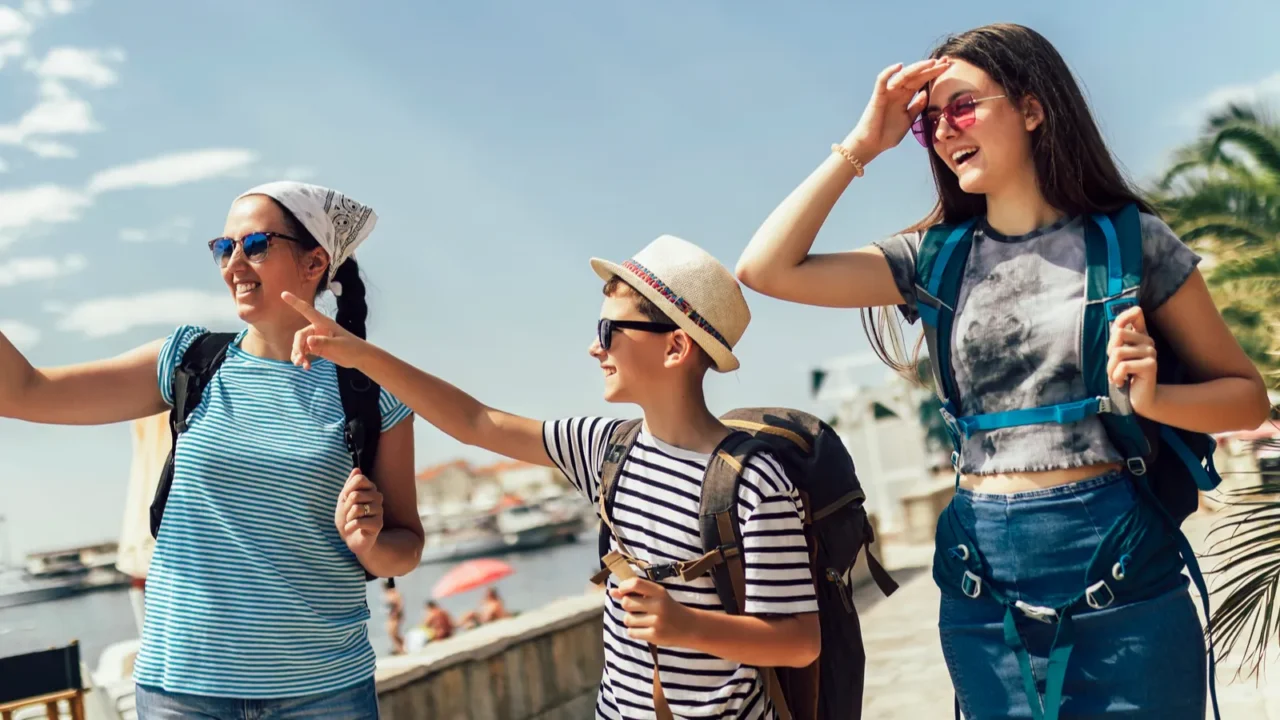 happy mother son and daughter walking together at seacoast with