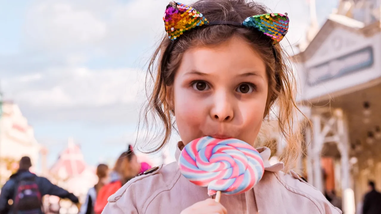 little girl with big lollipop is playing and having fun