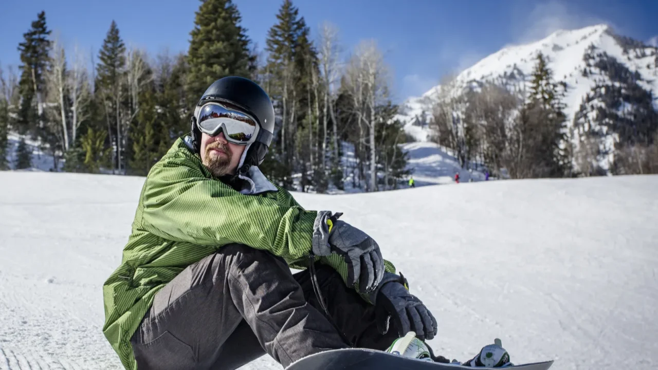 male adult snowboarder enjoying a day at a ski resort