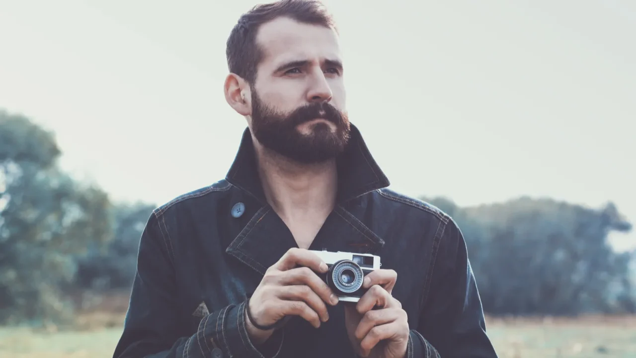 man holding retro camera
