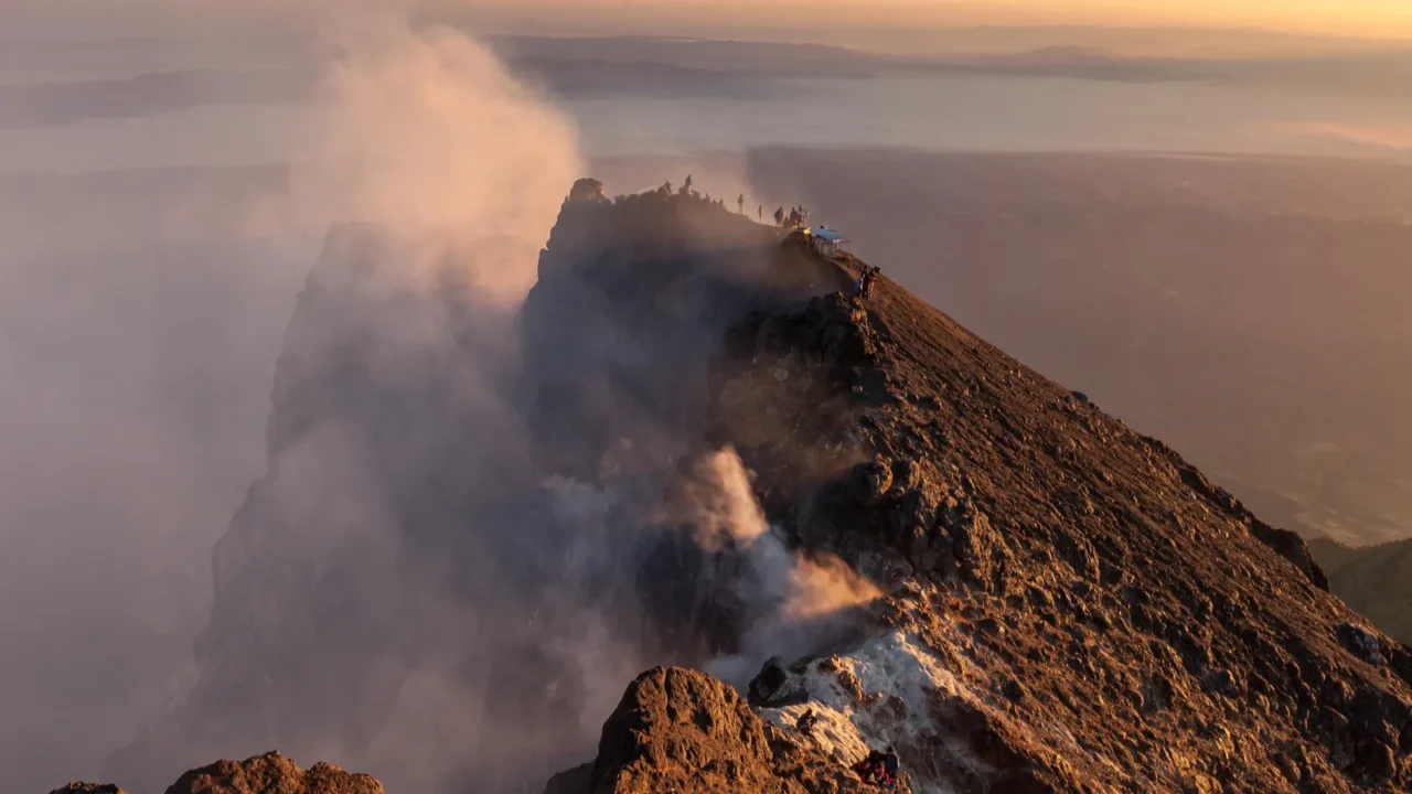 merapi volcano crater rim with people climbing up the summit