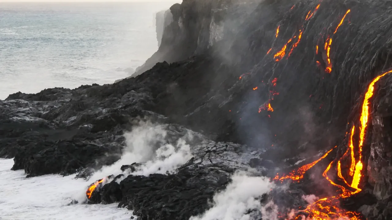 molten lava flowing into the pacific ocean on big island