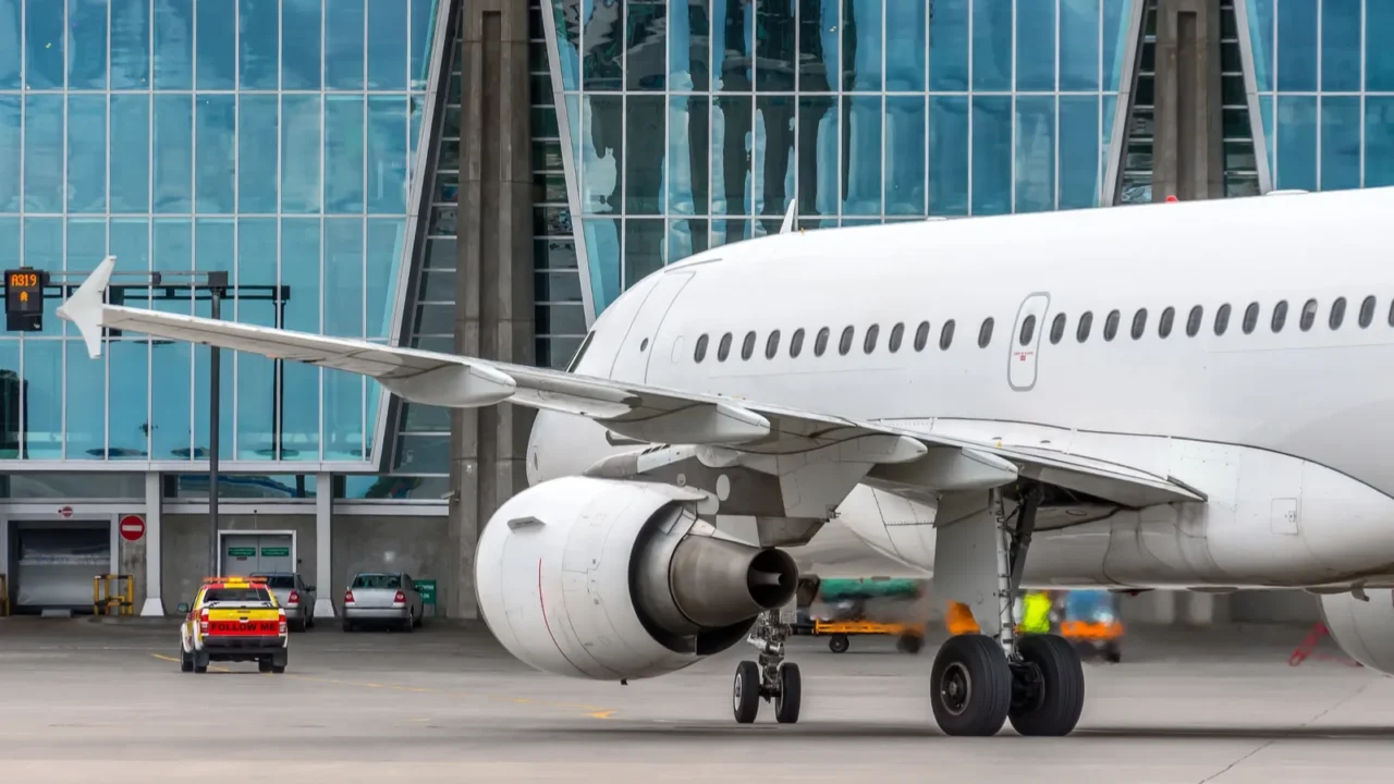 passenger airplane approaches the parking lot at the terminal behind