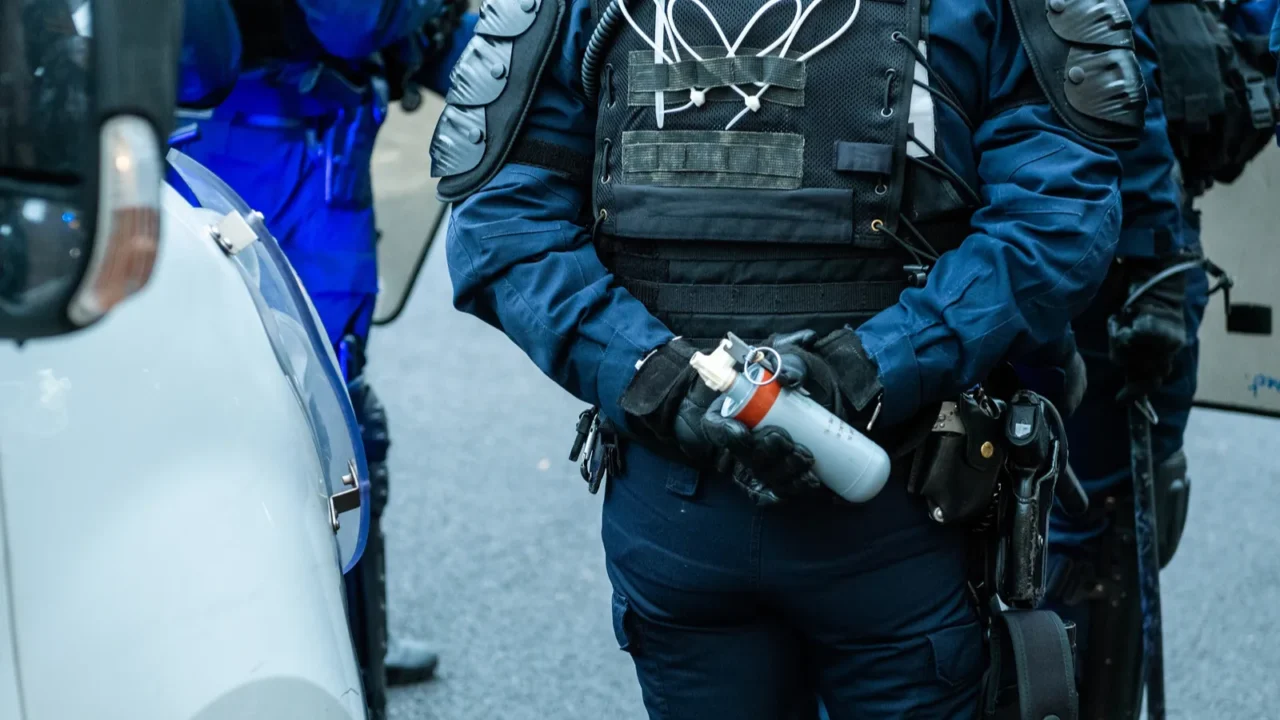 police officer holding tear gas ready to use it at