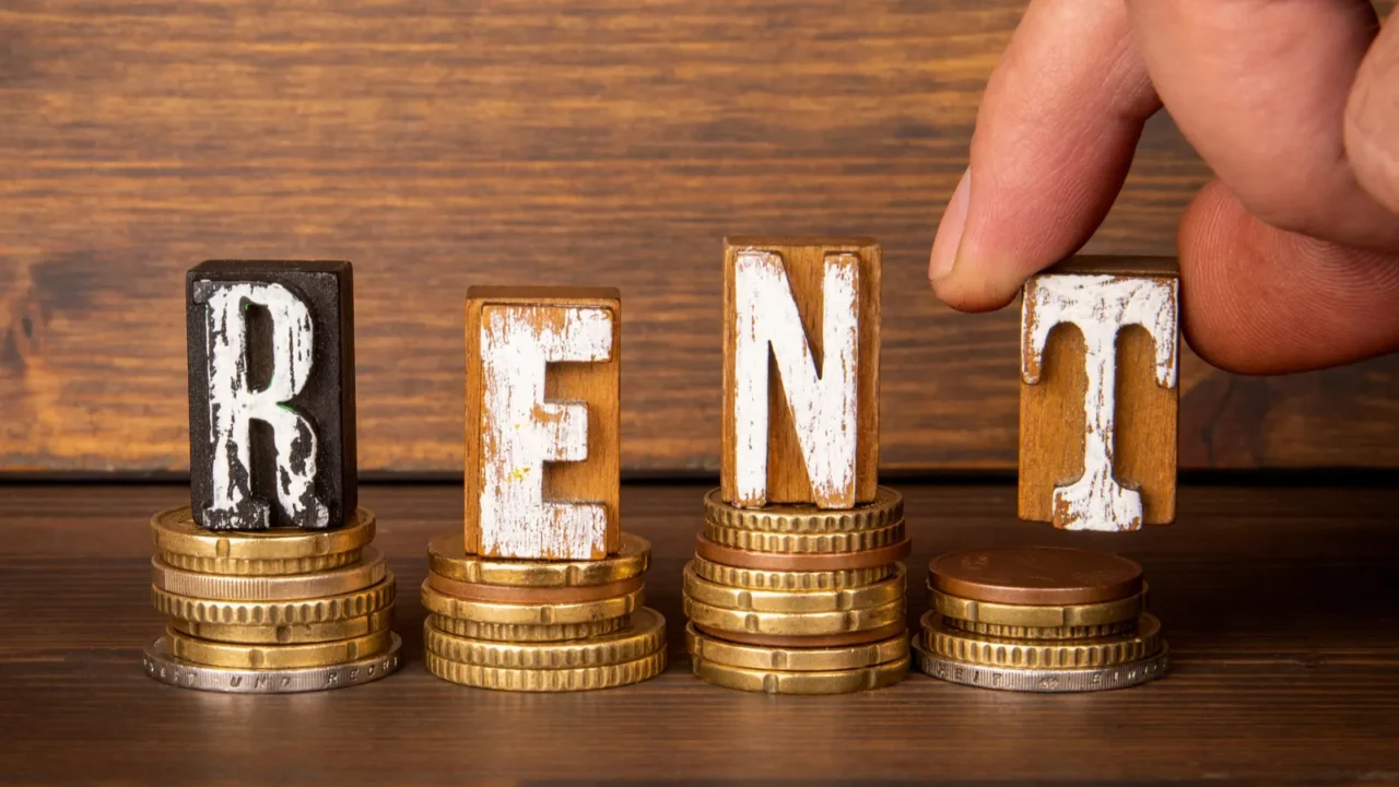 rent concept alphabet blocks and change on wood texture background