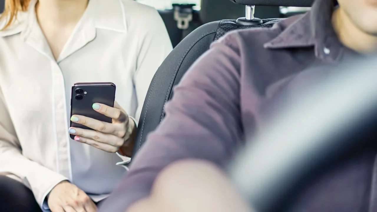 taxi or rideshare car passenger using phone to pay for