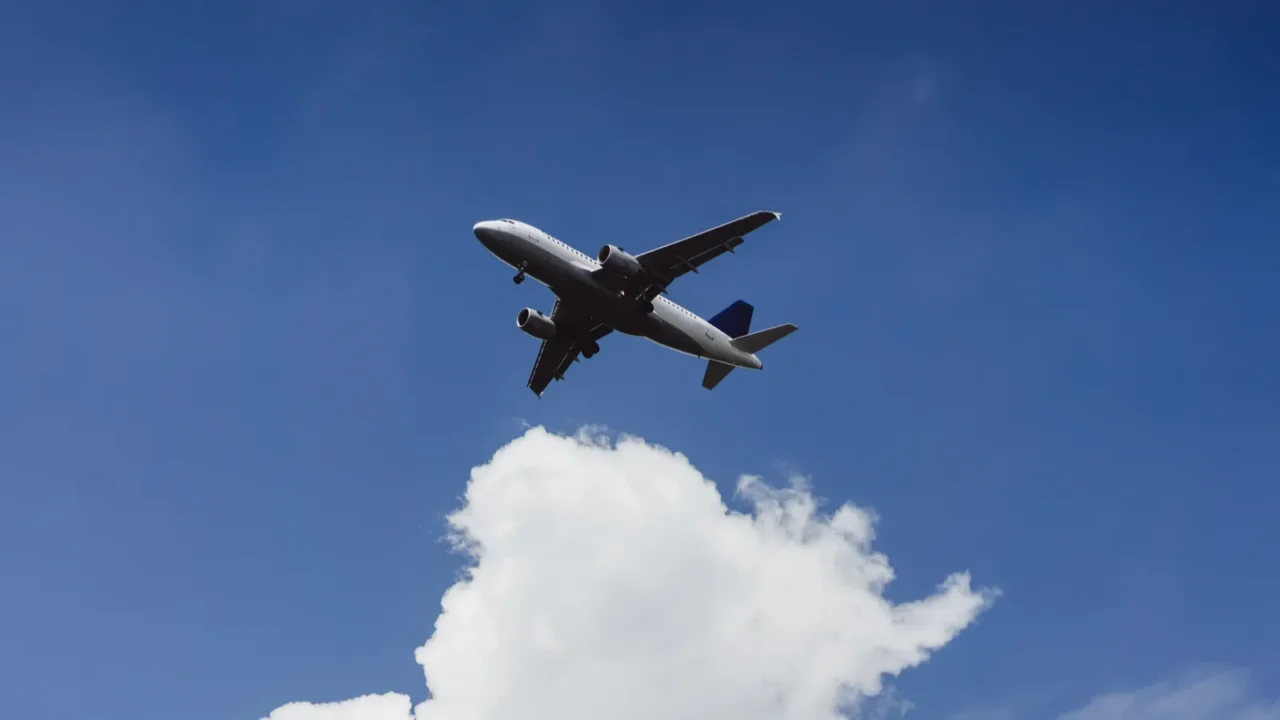 the plane is flying in the blue sky