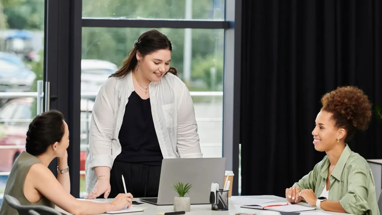 three professional women engage in a lively discussion while working