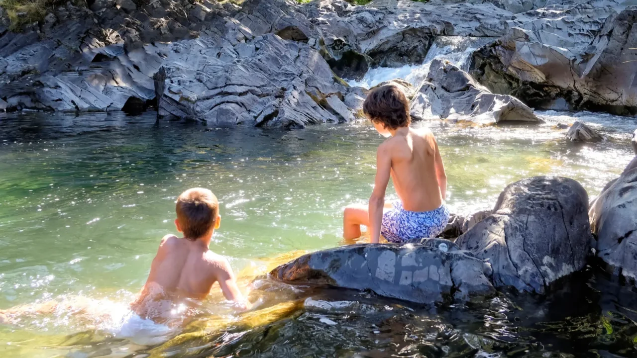 two boys on their backs enjoying a swim in a