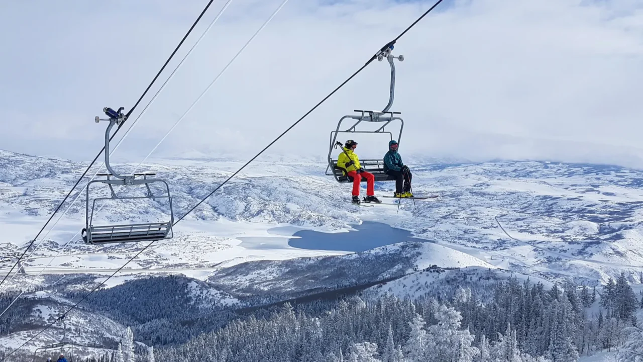 two tourists skiing in park city ride the chairlift to