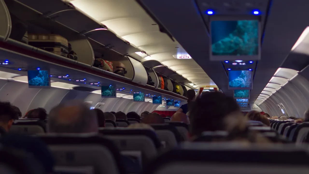 view from aircraft cabin showing rows of seats luggage racks
