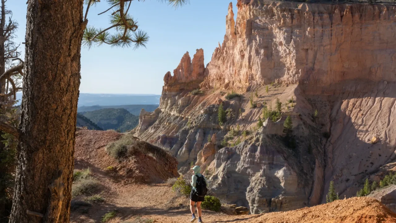 woman hikes the under the rim trail in bryce canyon