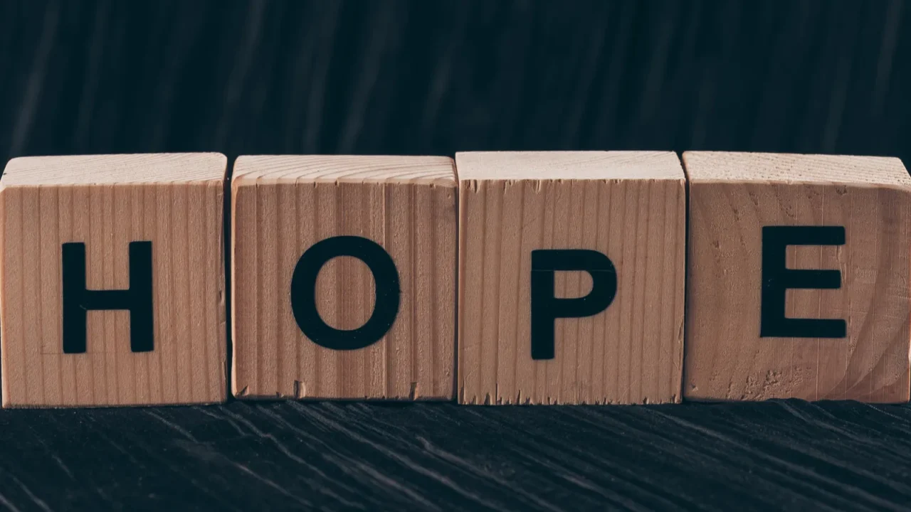 wooden cubes with word hope on black table