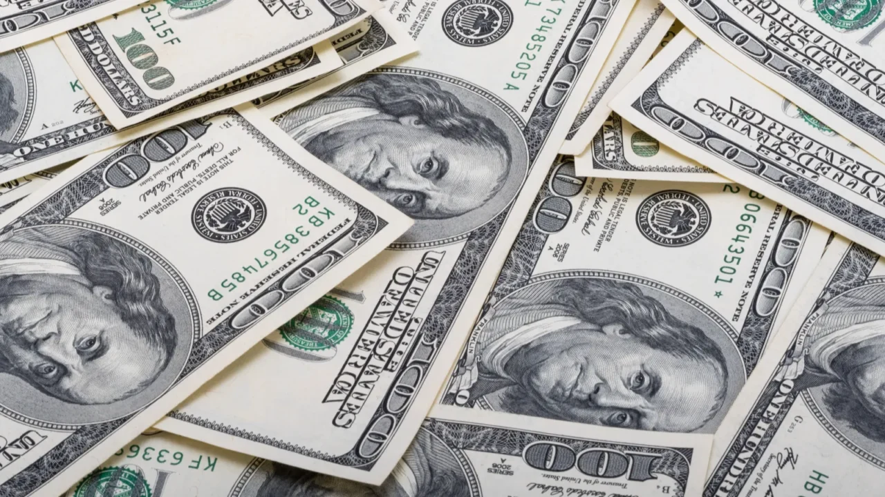 100 dollar bills on wooden background