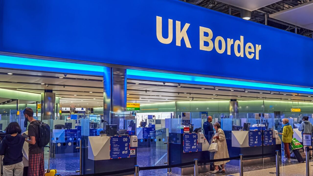 Air travelers queuing at border control in Heathrow Airport. London, UK.