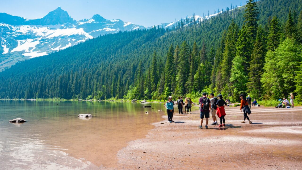 West Glacier, Montana, USA - 6-8-2025: Hikers admiring the mountains at Avalanche Lake in Glacier National Park
