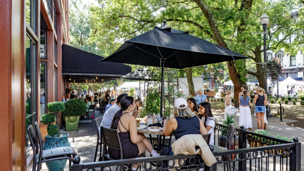 Knoxville, TN, USA-21 Sept. 2024: Adults and young women, possibly family, having a meal at an outside venue at Cafe 4 in Market Square.