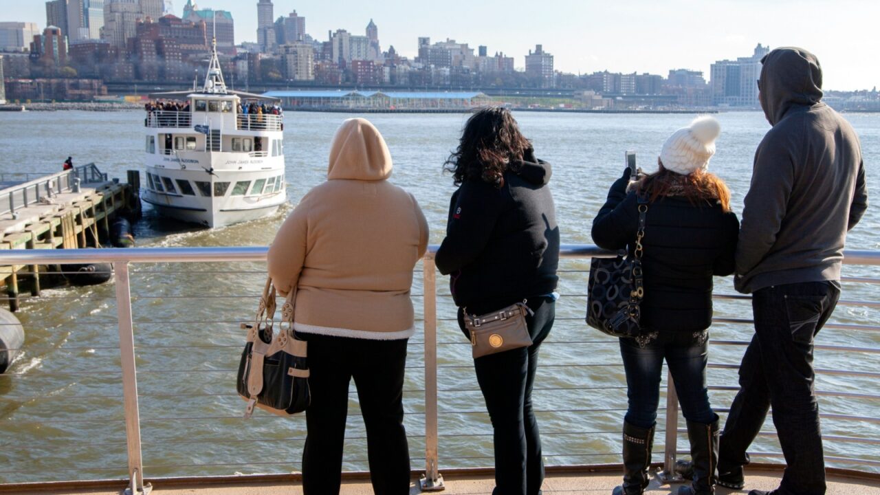 MANHATTAN , NEW YORK , USA - 2 of January 2016 :back view of people on the ship during the sightseeing tour with Brooklyn coastline on background. sunny winter day