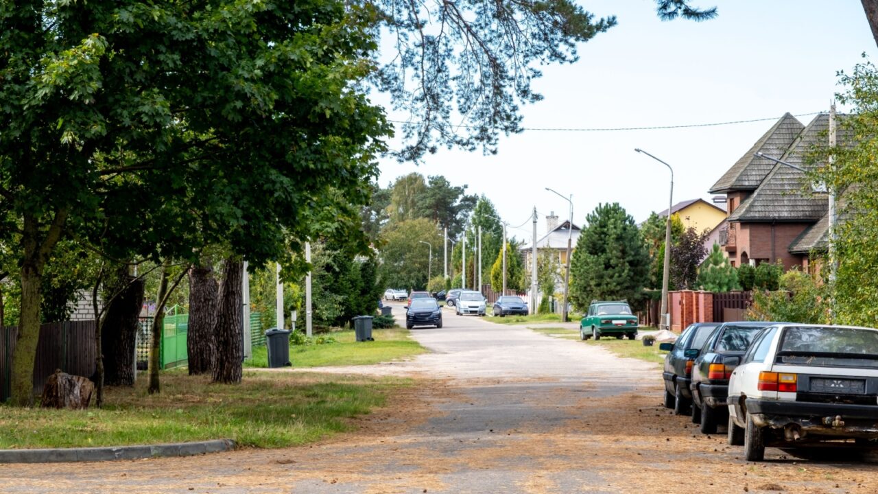 Asphalt street in a residential neighborhood of a small town among simple one-story houses