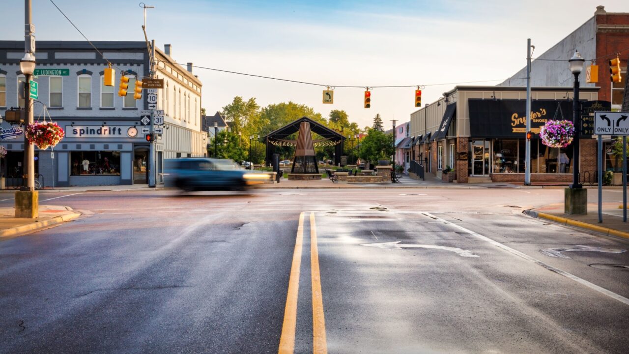 Ludington, Michigan, USA - July 20, 2023: The sun rises on the cool wet streets of an intersection at the downtown district.