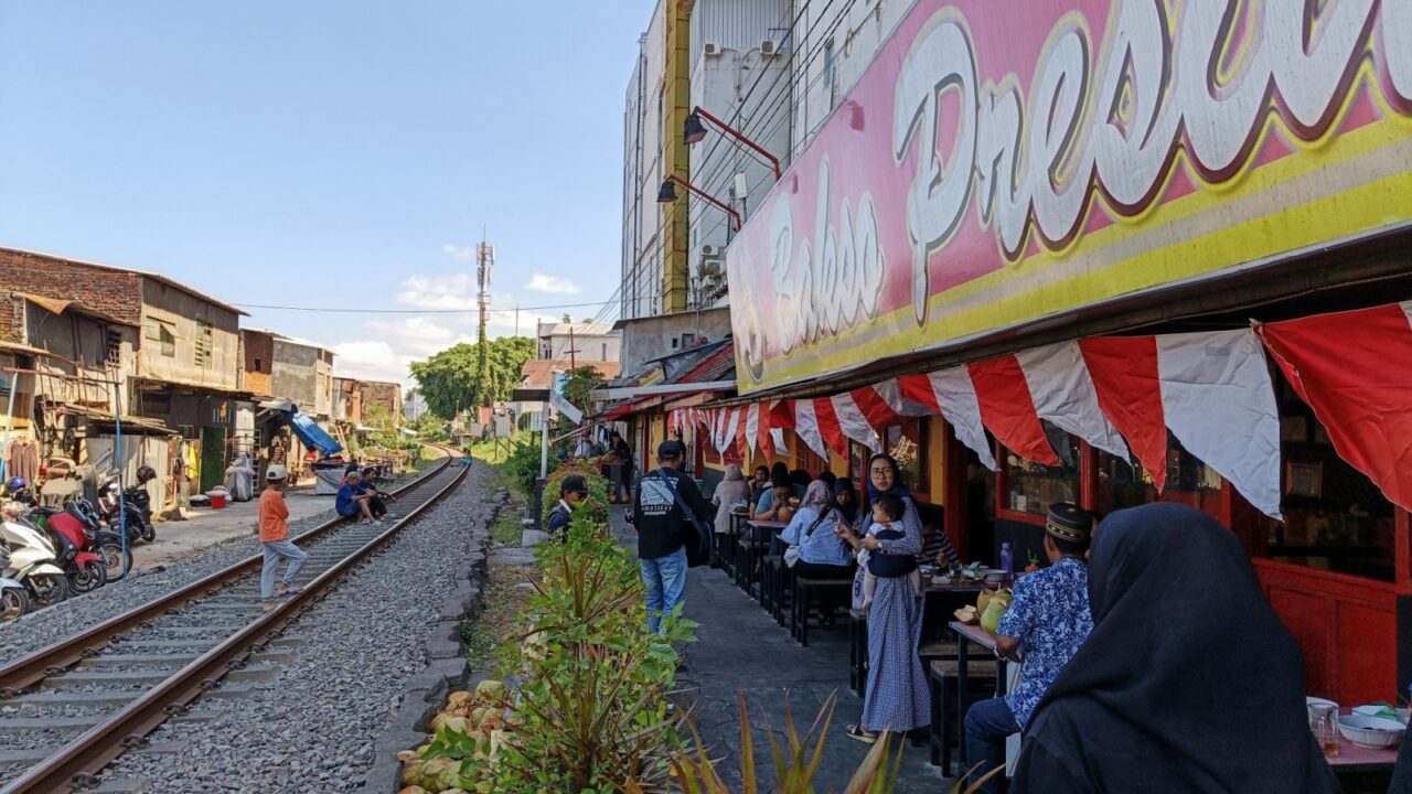 Malang, Indonesia, August 31 2024 - a food restaurant located next to the train tracks railway. a cafe next to the train tracks, sit and eat food while watch the trains
