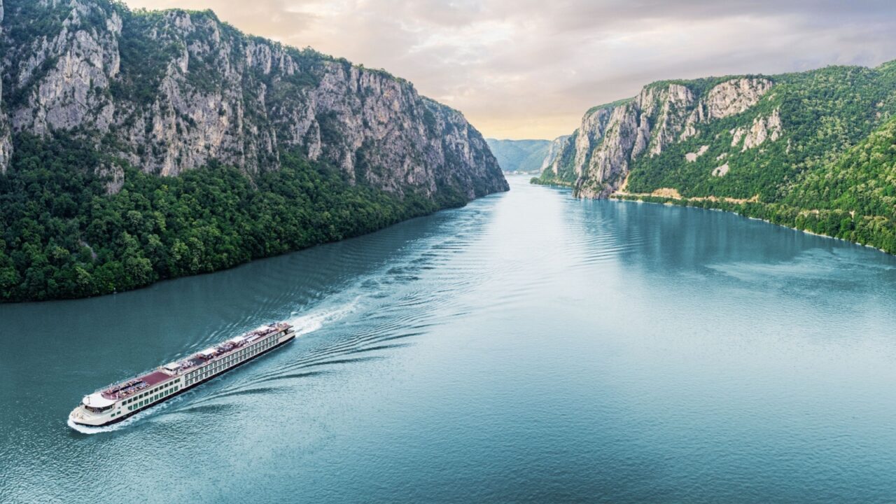 Passenger vessel cruising through the picturesque Iron Gate Gorge on a summer vacation trip