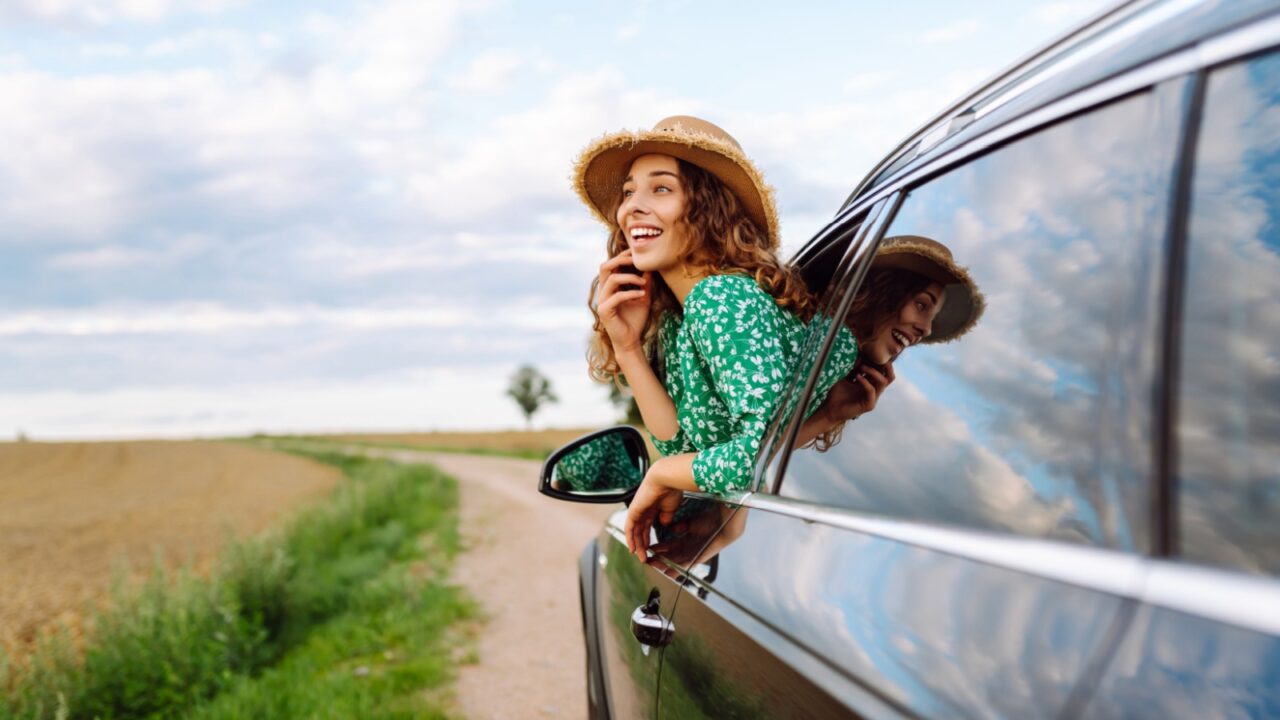Woman tourist on road, enjoying window view and traveling on holiday road trip. Travel adventure drive.