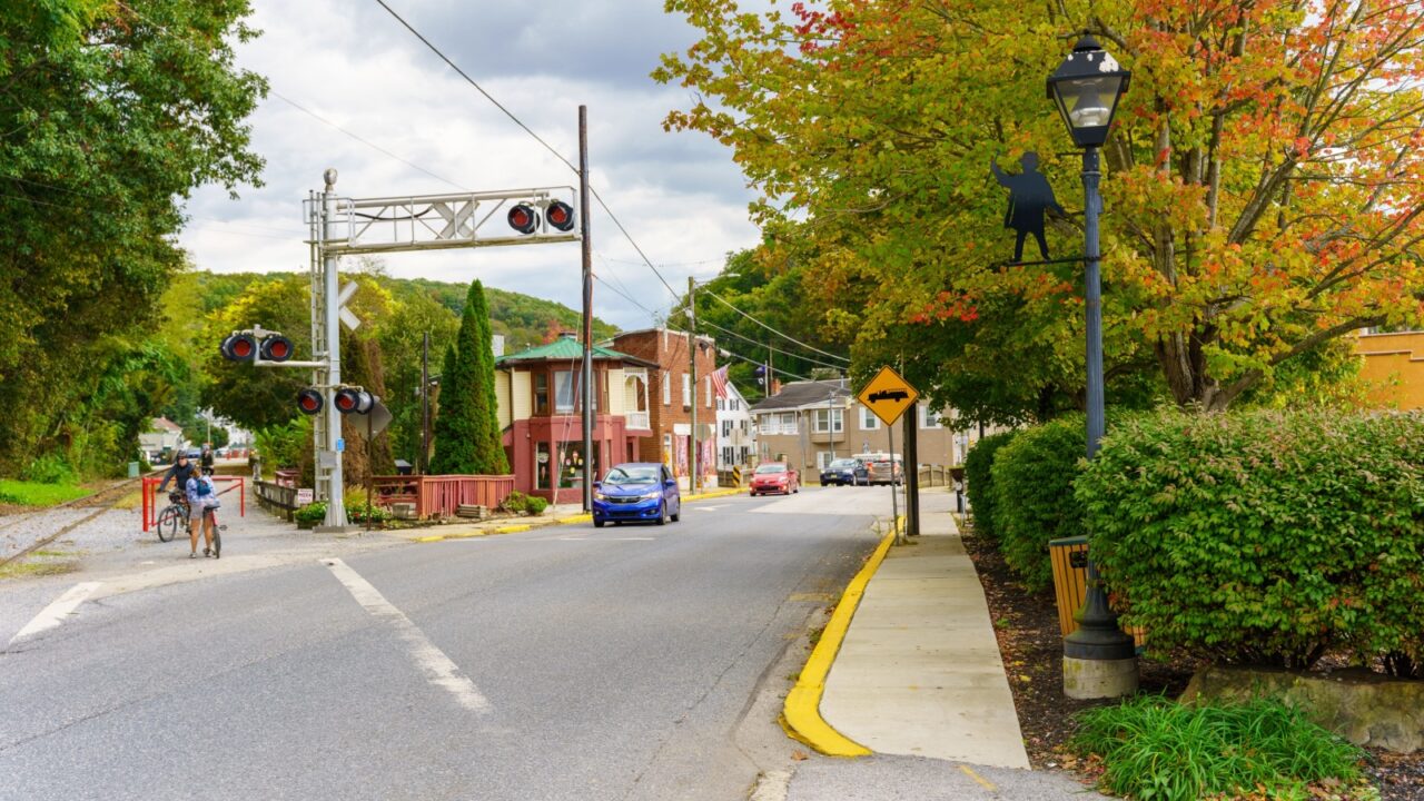 Glen Rock, PA, USA - October 17, 2021: Bicycle riders using the York County Heritage Rail Trail park system await traffic to cross a downtown street.