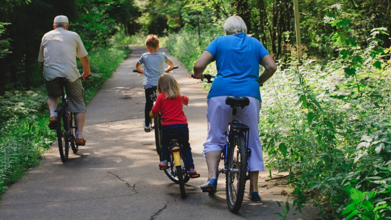 active senior couple with kids riding bikes in nature