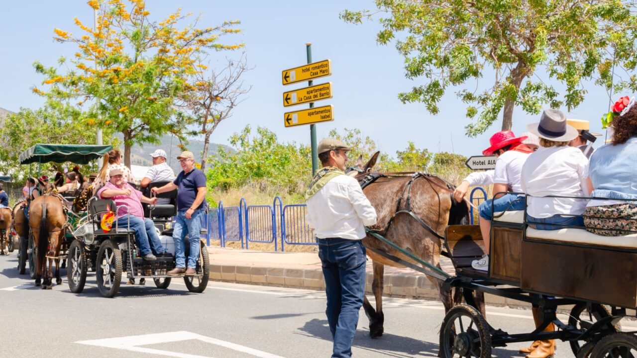 NERJA, SPAIN - 15 MAY 2022 City residents, carriages, carts, horses, oxen and tractors, as well as local farmers coming from neighbouring villages all dressed in the best and most beautiful folk cost