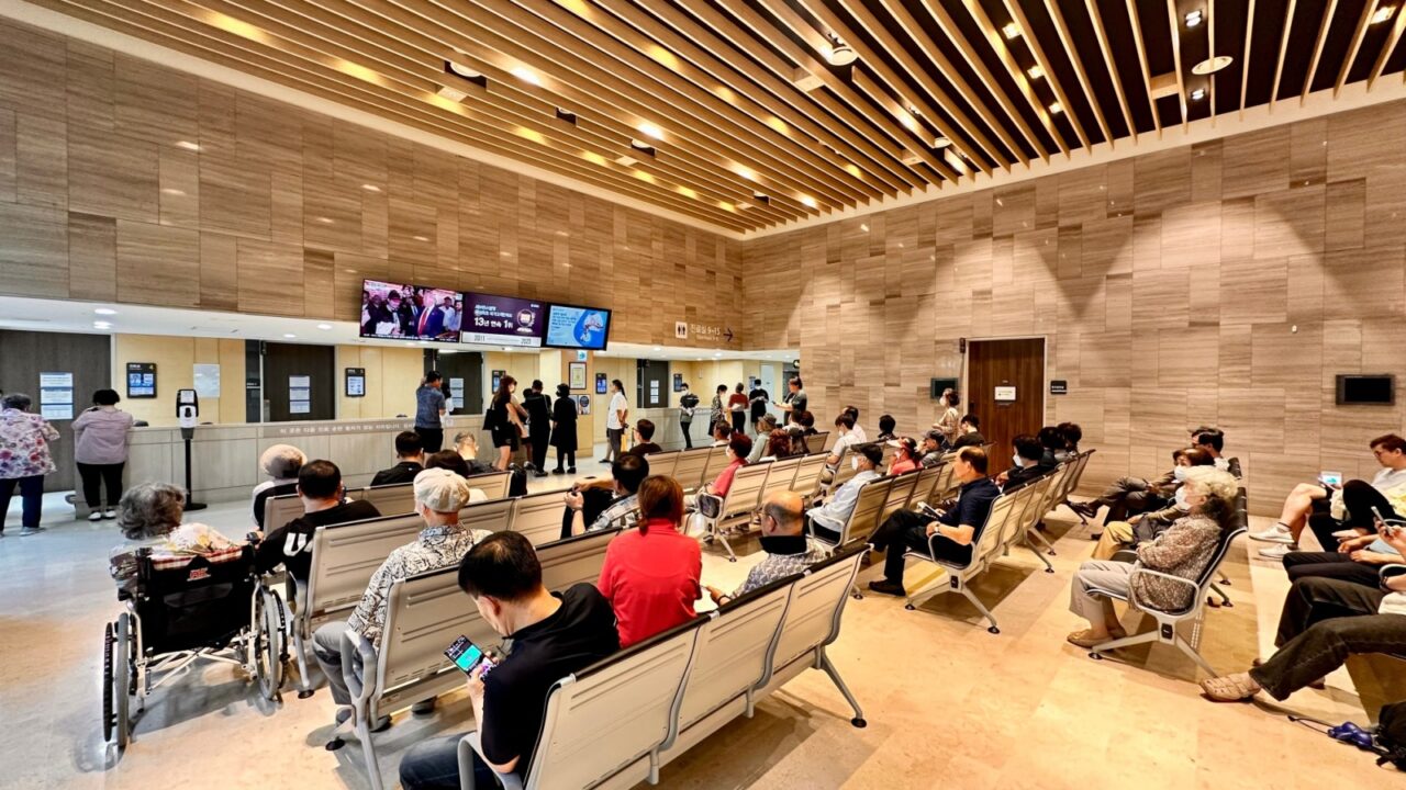 Seoul, South Korea - October 15, 2024 A busy hospital waiting area filled with patients and caregivers seated on benches.