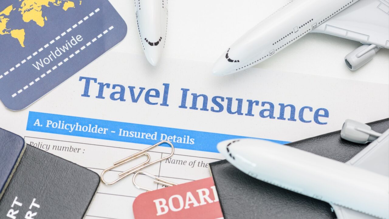 Travel insurance and service concept : Top view of travel insurance application form, a boarding pass, passport, airplanes. Travel insurance covers costs and losses associated with traveling.