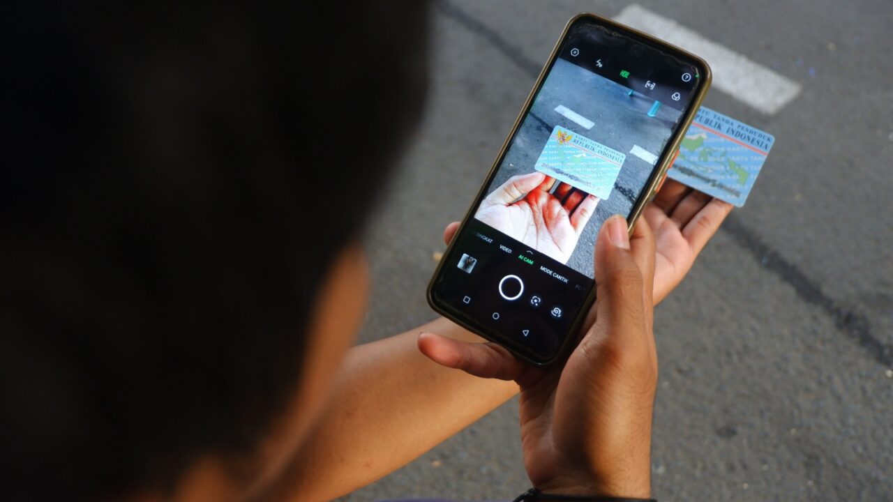Jakarta, Indonesia, December 18, 2023. Asian man takes a photo of his Indonesian National Identity Card (KTP) using a cell phone