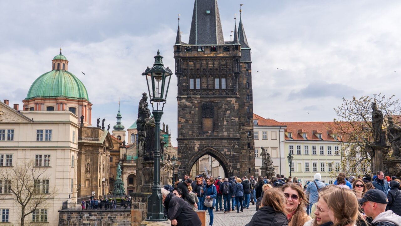 Prague, Czech Republic - April 5, 2025: View of Charles Bridge over the Vltava River and people walking around the city