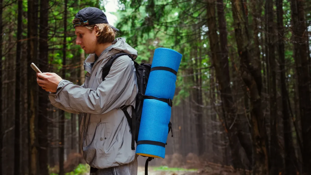 a male tourist with a backpack stands on a mountain