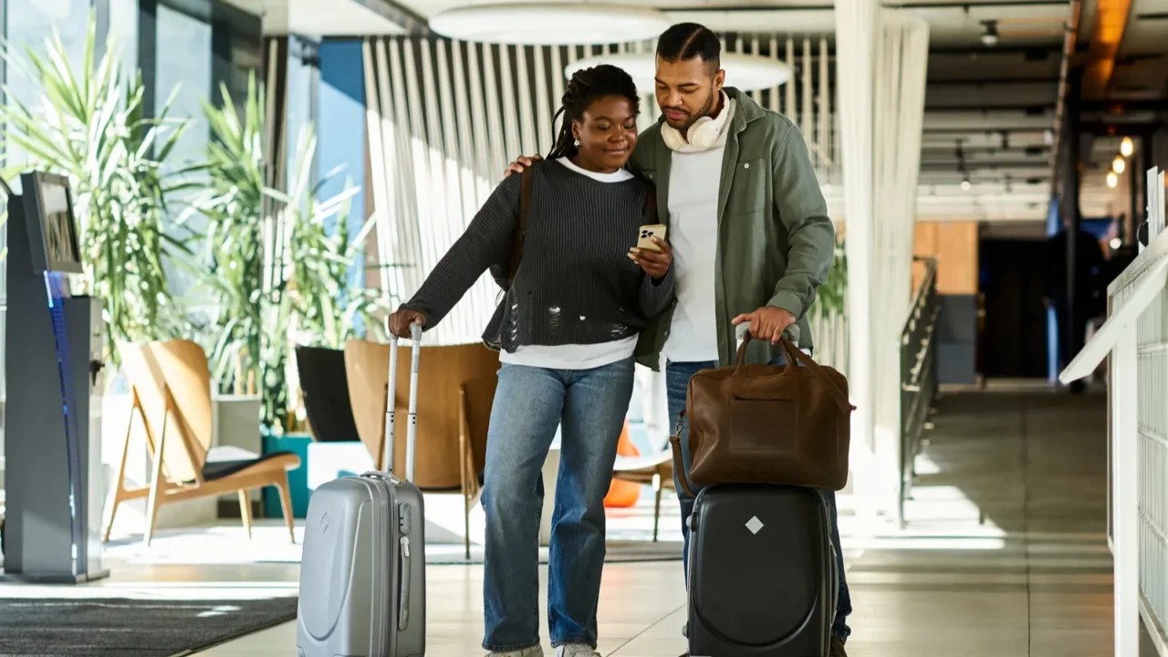 a young couple joyfully arrives at a modern hotel lobby