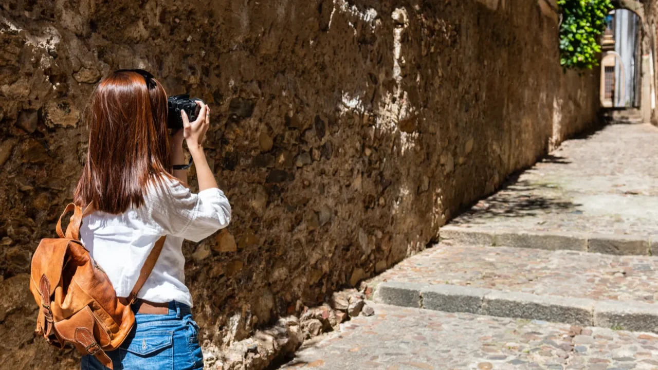 a young redhaired tourist takes photographs with her camera of